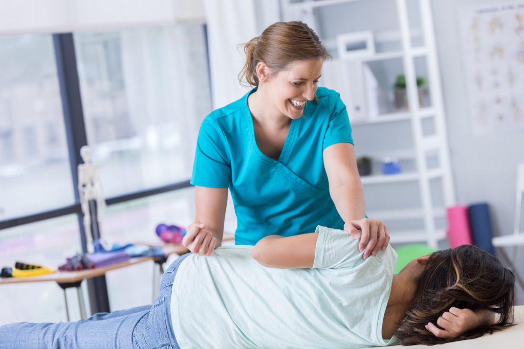 Female Chiropractor adjustinga woman's back in Thomasville.